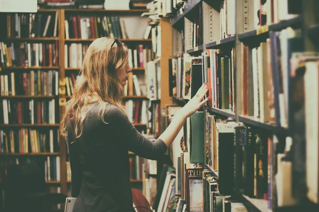 an image of a women in library looking for books