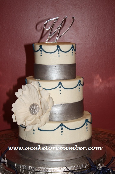 This cake had silver chocolate fondant bands and navy blue piping