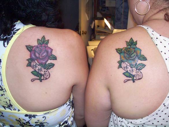 Two sisters with matching custom tattoos of a purple rose and a green tattoo