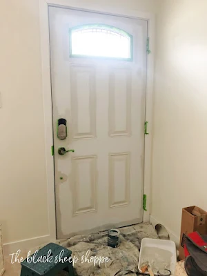 Gray paint being applied to white door.