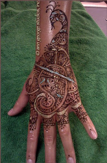 gilded henna tattoo back of hand peacock pattern