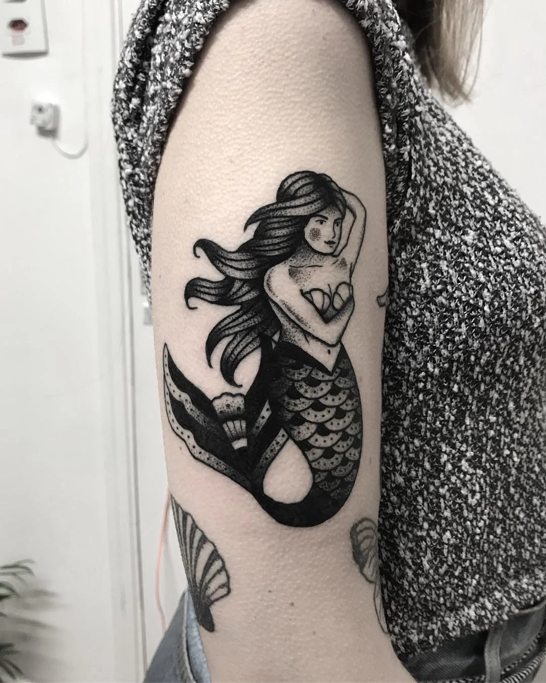 Fotografía del tatuajes de una sirena en la piel de una mujer