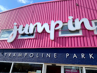 Sign in front of a building reads Jump In trampoline park