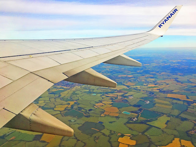 Wing of a RyanAir plane flying over the Romanian countryside