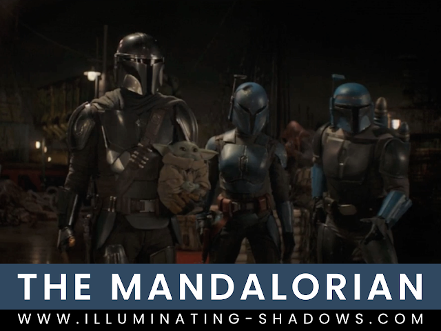 The Mandalorian - Season 2 - Chapter 11 - Picure of the Mandalorian Din Djarin holding the Child Grogu next to two other Mandalorians