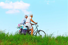 An elderly couple ride bicycles together