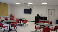 ACCESS lab with monitor, tables, and teacher station