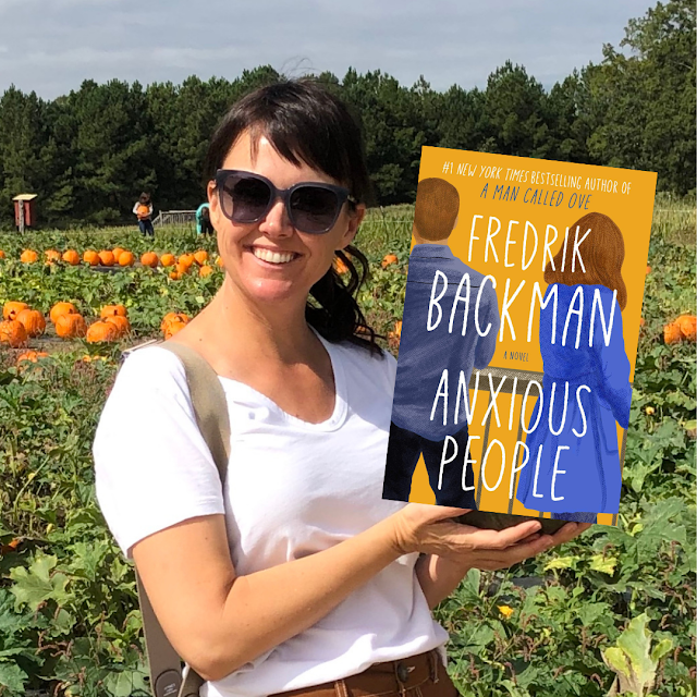 woman holding a book in a pumpkin patch