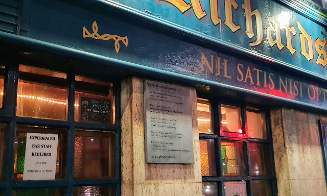 Pub wall with plaque of Rita Ann Higgins's poem 'Men With Tired Hair' was unveiled by Professor Adrian Frazier at Richardson's Bar, No. 1 Eyre Square, Galway as part of the Cuirt International Festival of Literature on April 8th, 2014.   The poem:    On a bank holiday Monday in Galway you can see old men sitting on window sills in Prospect Hill.  Time is not a factor here only images, pleasing and displeasing to the men with tied hair.  Despite this easiness with life there is waiting a look-out in anticipation of something  The looking up and down continues the awaited stimulus always comes  Days it's a young woman Streets it's a fire. Years it's news of a tragedy in far-off Dublin.