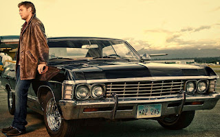 Joshua's brother Jensen Ackles posing for a picture with a classic car
