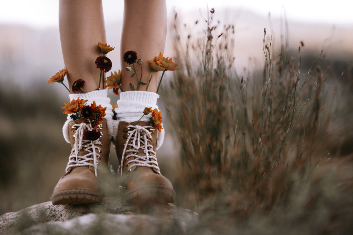 close-up of female legs wearing combat boots with dry flowers inside