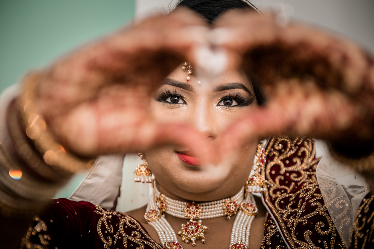 The bride making a symbol of love that unites her and her handsome man.