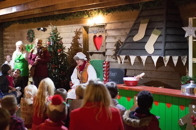 Mother Christmas sitting in a chair in front of children