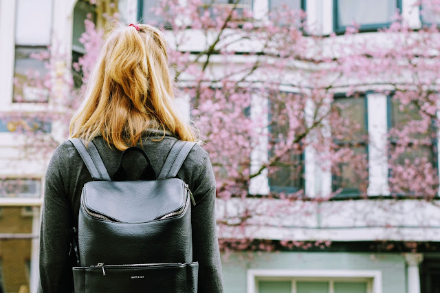 Mulher de costas com uma mochila preta