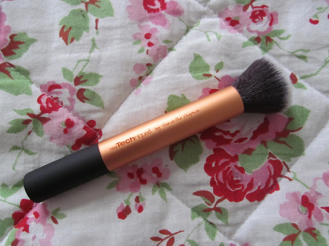 large gold makeup brush with black bristles