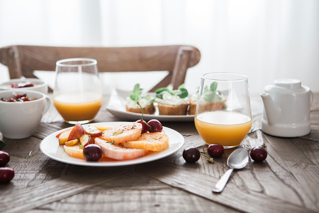 plate of fresh fruit and glasses of juice