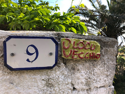 A sign written in the Sicilian dialect indicating the name of a house, 'an old place'.