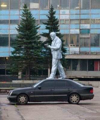 Statue is standing above the car illusion