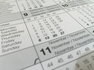 A close-up view of a calendar, showing the number of each month as well as its name in six languages, and the days of the month corresponding to days of the week with their English names. Each week is also sequentially numbered. The month of September is fully visible, while October and November are visible in part.