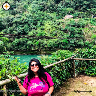 Visitante emocionada capturando el momento y tomándose una foto con el río Jatunyaku de fondo en las impresionantes Lagunas Yany, llenando el recuerdo con alegría y belleza natural.