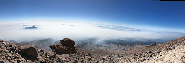 rocky mountain side looking down on clouds