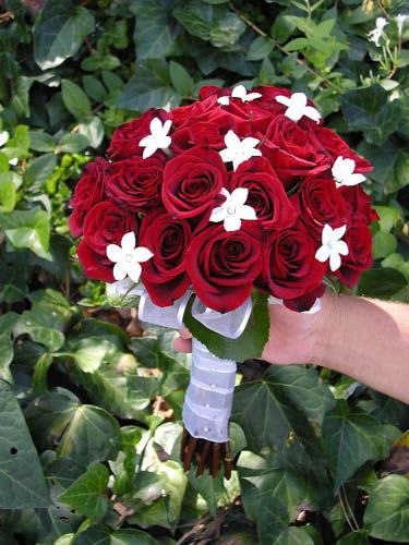 A selection of beautiful bridal bouquets made with deep red roses and small