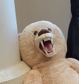 A huge teddy bear viciously showing its fangs.