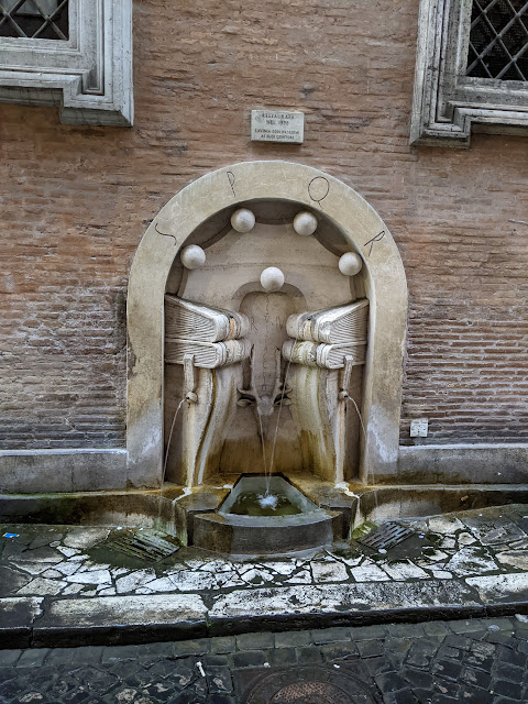 A picture of a fountain decorated with carved books.