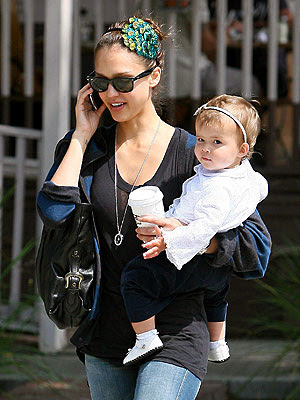 Jessica Alba carries her 11-month-old daughter Honor whilst catching up on 