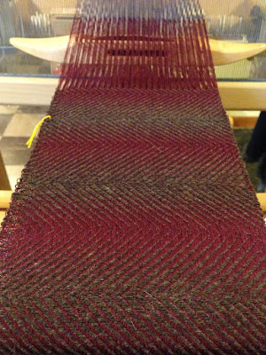 Several repeats of a brown and maroon diagonal twill design that looks like rows of raw tuna filet.