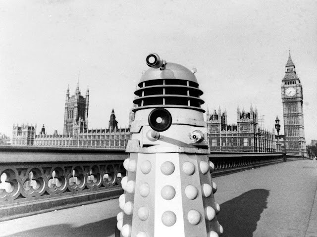 A Dalek on Westminster Bridge, aiming its gun-stick at us, the Houses of Parliament behind