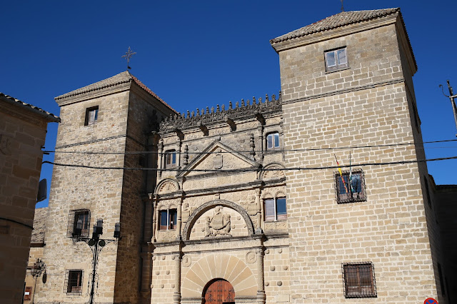 Gran edificio de ladrillos con dos torres una a cada lado, con aspecto de castillo o fortaleza.