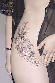 Sensual imagen con flores tatuada en la cadera de la mujer