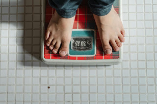 Ilustrasi seseorang mengukur berat badan.