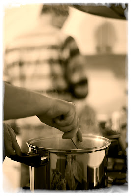 Pans steam and two people cooking