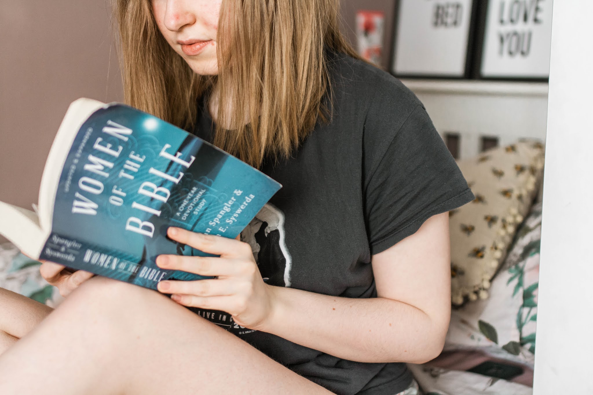 blonde haired girl reading blue devotional book