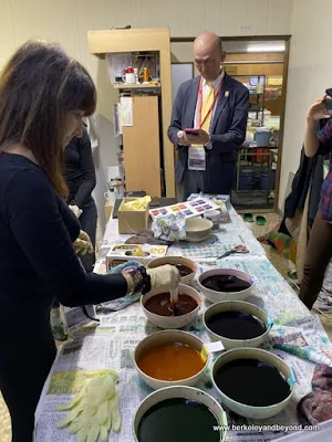 student dips tie-died cloth at Geocolor:  Hachimantai Geothermal Dyeing in Hachimantai city, Japan