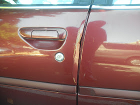 Dented door on 2000 Nissan Altima before collision repairs at Almost Everything Auto Body