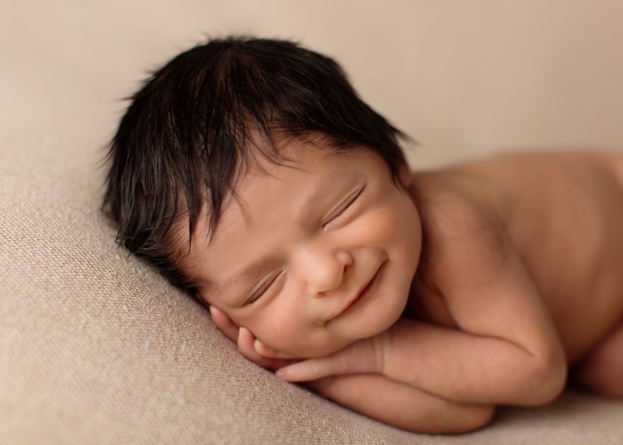 the photographer catches the smiles of sleeping babies