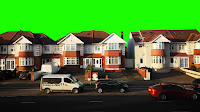 Cars on road in Residential Hounslow, London with bright green sky..