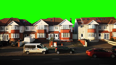 Cars on road in Residential Hounslow, London with bright green sky..