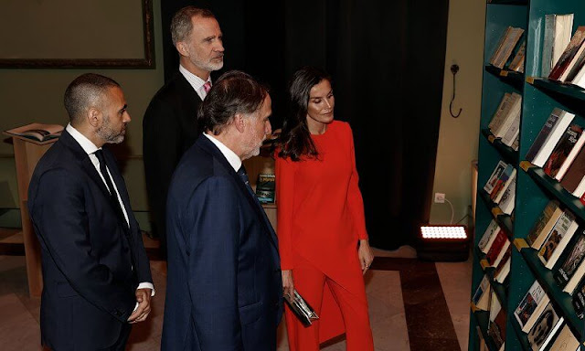 Queen Letizia wore a red coral asymmetric top and coral trousers by Zara. CXC gold earrings. Magrit gold leather pumps