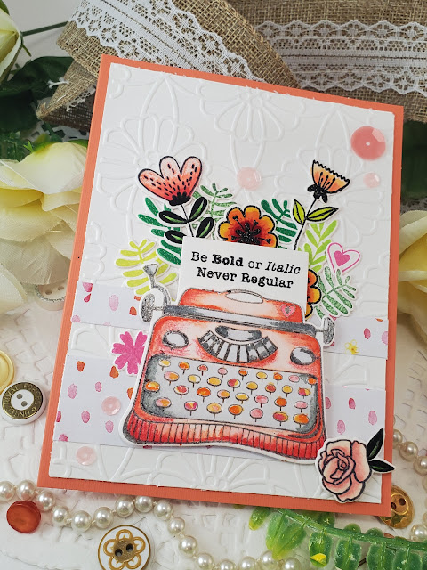 Orange type writer with floral accents on a greeting card. The text reads "Be bold or italic. Never regular"