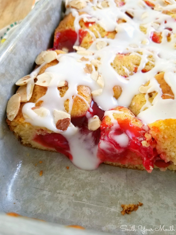 Cherry Danish Cake! An easy semi-homemade cake recipe dotted with cherry pie filling, drizzled with sour cream icing and topped with slivered almonds that tastes just like cherry danish!