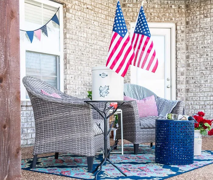 wicker chairs, patriotic flag garland, blue rug, gingham pillows