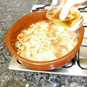 Cazuela con verduras cocinándose y vaciando un vaso de cerveza