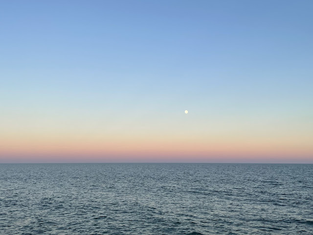 A view of the ocean from our picnic table after the sun had set. The sky is a twilight in color with a pinkish purplish hue along the horizon.