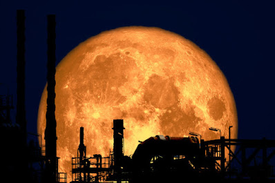 Gambar bulan purnama di antara gedung metropolitan