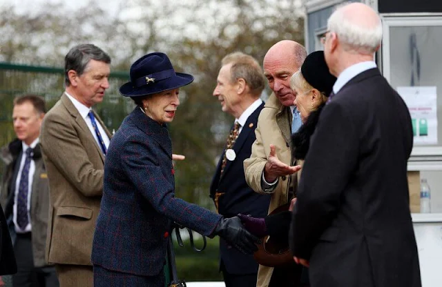 The Princess Royal wore a navy blue and red tartan suit. Princess Anne's jacket featured a folded collar and bright red buttons