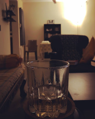 A glass of whiskey in Christopher's dimly lit living room
